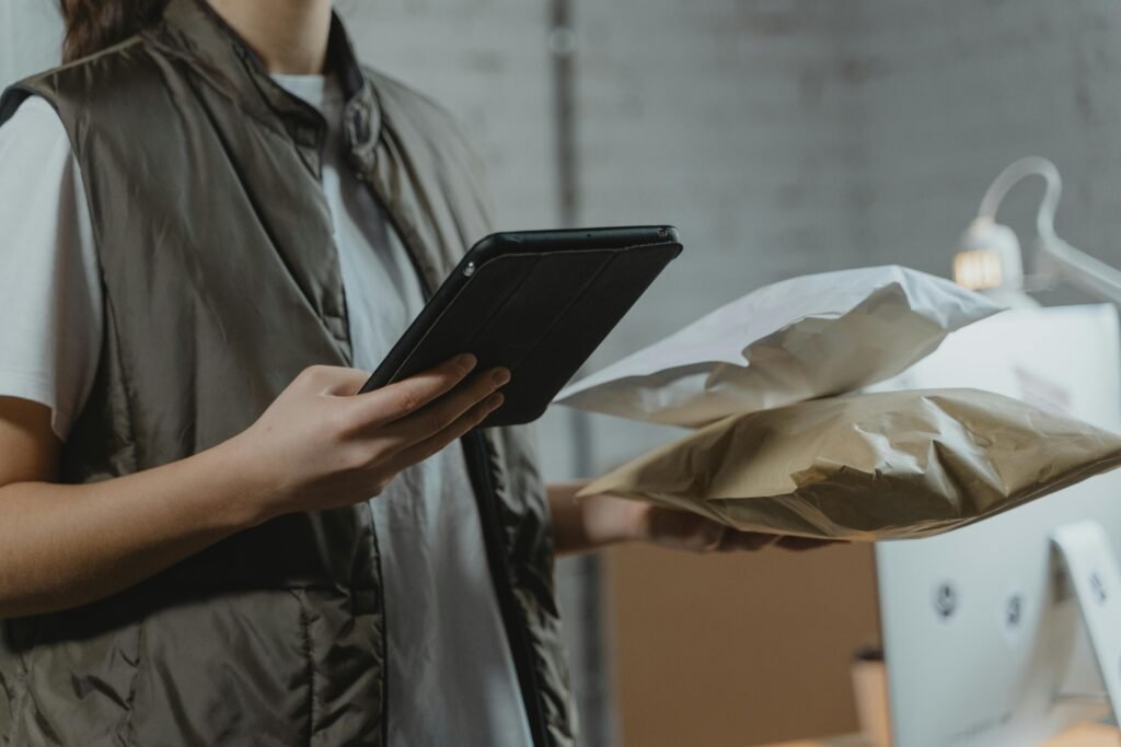 pexels-photo-6170399-6170399 A person using a tablet to manage packages in an indoor setting, highlighting technology and logistics.