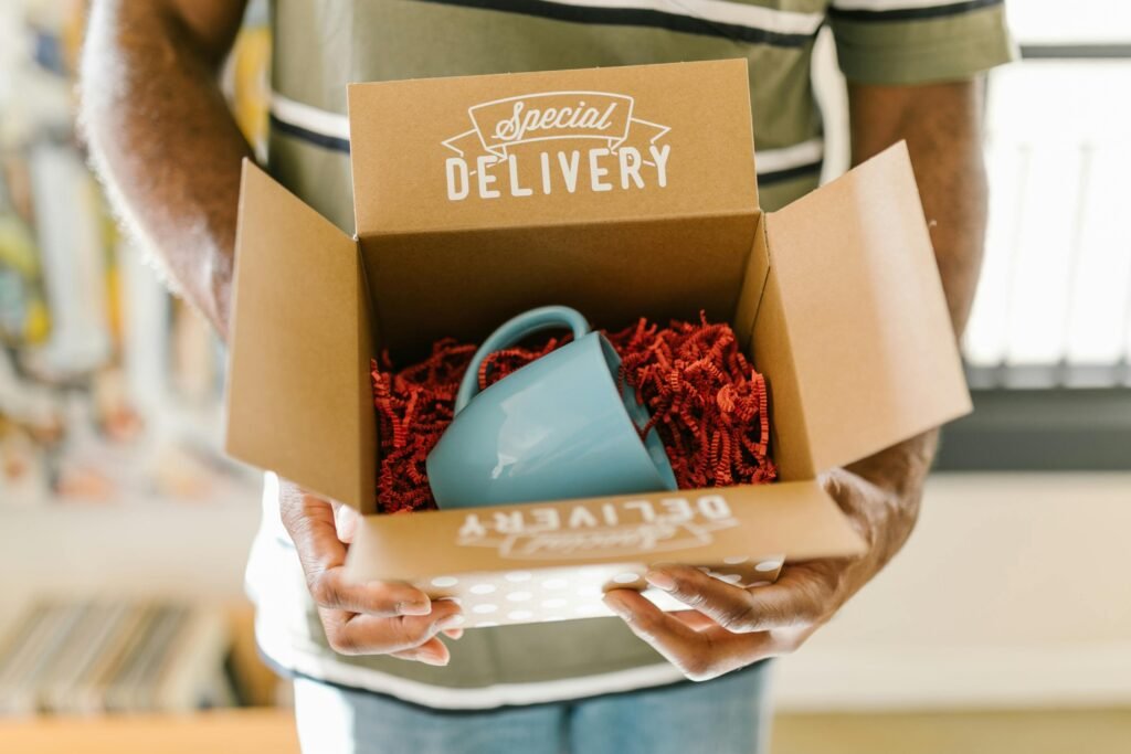 pexels-photo-7310206-7310206 Man holding a box with a special delivery coffee mug inside.